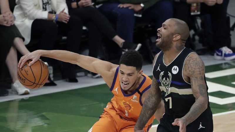 Phoenix Suns guard Devin Booker (1) works the ball against Milwaukee Bucks guard Bryn Forbes (7) during the first half of Game 6 of basketball's NBA Finals Tuesday, July 20, 2021, in Milwaukee. (AP Photo/Aaron Gash)