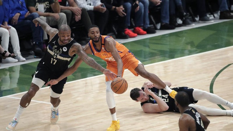 Phoenix Suns guard Devin Booker (1) works the ball against Milwaukee Bucks guard Bryn Forbes (7) during the first half of Game 6 of basketball's NBA Finals Tuesday, July 20, 2021, in Milwaukee. (AP Photo/Aaron Gash)