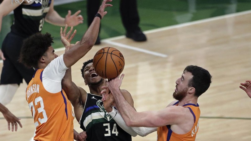 Phoenix Suns guard Devin Booker (1) works the ball against Milwaukee Bucks guard Bryn Forbes (7) during the first half of Game 6 of basketball's NBA Finals Tuesday, July 20, 2021, in Milwaukee. (AP Photo/Aaron Gash)