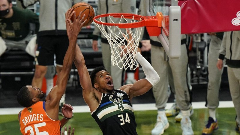 Phoenix Suns guard Devin Booker (1) works the ball against Milwaukee Bucks guard Bryn Forbes (7) during the first half of Game 6 of basketball's NBA Finals Tuesday, July 20, 2021, in Milwaukee. (AP Photo/Aaron Gash)