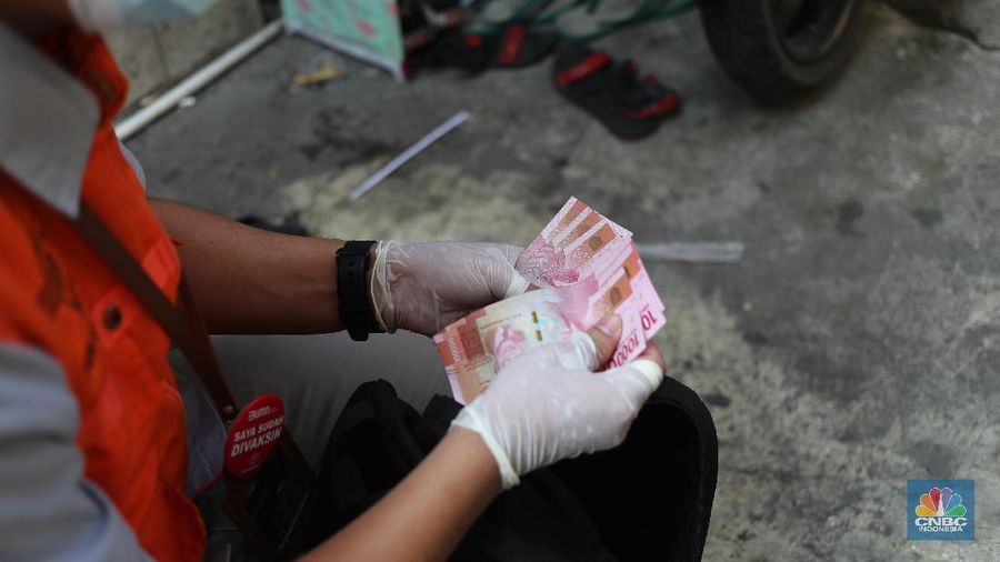 Petugas PT Pos Indonesia melakukan penyaluran Bantuan Sosial Tunai secara door to door di Kawasan Petojo Selatan, Jakarta, Rabu (21/7/2021). Tahun ini bansos (BST) ditargetkan untuk menjangkau hingga 10 juta keluarga penerima, penyaluran pun dilakukan secara bertahap.
(CNBC Indonesia/ Tri Susilo)