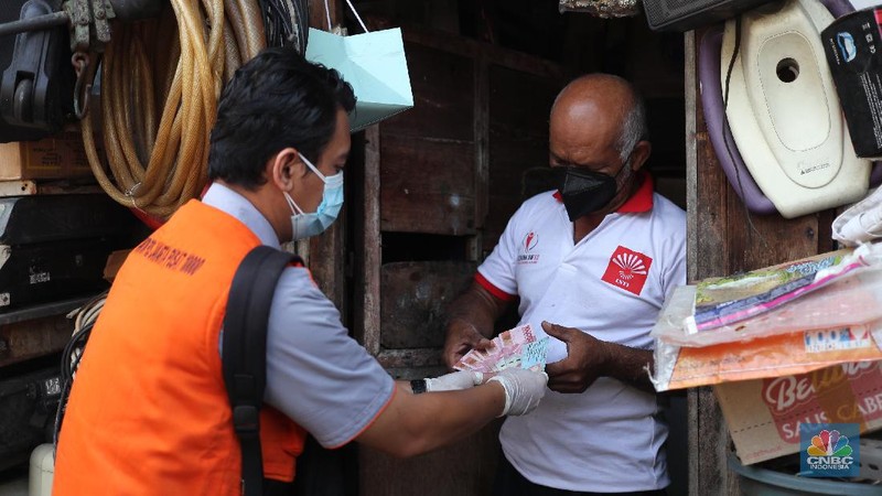 Petugas PT Pos Indonesia melakukan penyaluran Bantuan Sosial Tunai secara door to door di Kawasan Petojo Selatan, Jakarta, Rabu (21/7/2021). Tahun ini bansos (BST) ditargetkan untuk menjangkau hingga 10 juta keluarga penerima, penyaluran pun dilakukan secara bertahap. 
 (CNBC Indonesia/ Tri Susilo)