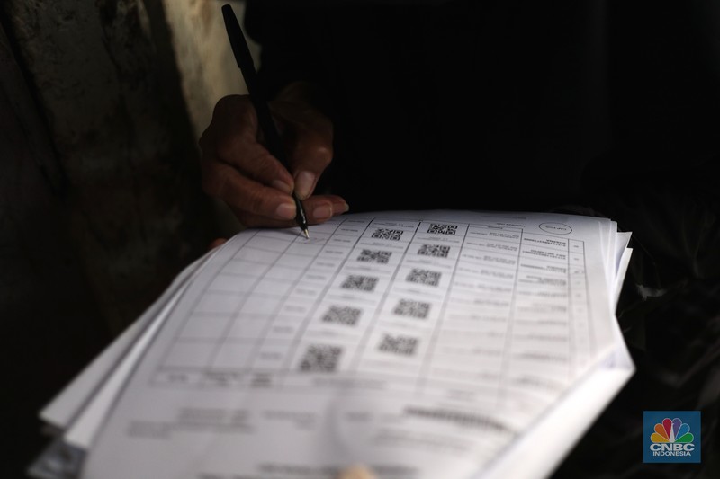 Petugas PT Pos Indonesia melakukan penyaluran Bantuan Sosial Tunai secara door to door di Kawasan Petojo Selatan, Jakarta, Rabu (21/7/2021). Tahun ini bansos (BST) ditargetkan untuk menjangkau hingga 10 juta keluarga penerima, penyaluran pun dilakukan secara bertahap. 
 (CNBC Indonesia/ Tri Susilo)