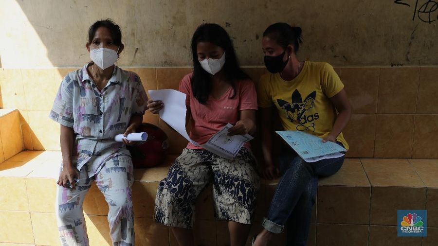 Petugas PT Pos Indonesia melakukan penyaluran Bantuan Sosial Tunai secara door to door di Kawasan Petojo Selatan, Jakarta, Rabu (21/7/2021). Tahun ini bansos (BST) ditargetkan untuk menjangkau hingga 10 juta keluarga penerima, penyaluran pun dilakukan secara bertahap. 
 (CNBC Indonesia/ Tri Susilo)