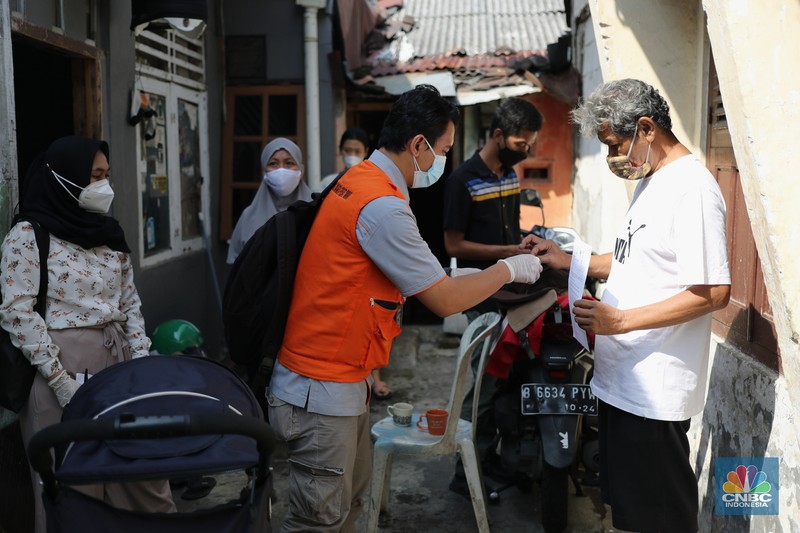 Petugas PT Pos Indonesia melakukan penyaluran Bantuan Sosial Tunai secara door to door di Kawasan Petojo Selatan, Jakarta, Rabu (21/7/2021). Tahun ini bansos (BST) ditargetkan untuk menjangkau hingga 10 juta keluarga penerima, penyaluran pun dilakukan secara bertahap. 
 (CNBC Indonesia/ Tri Susilo)