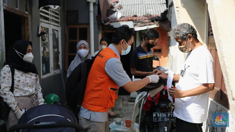 Petugas PT Pos Indonesia melakukan penyaluran Bantuan Sosial Tunai secara door to door di Kawasan Petojo Selatan, Jakarta, Rabu (21/7/2021). Tahun ini bansos (BST) ditargetkan untuk menjangkau hingga 10 juta keluarga penerima, penyaluran pun dilakukan secara bertahap. 
 (CNBC Indonesia/ Tri Susilo)