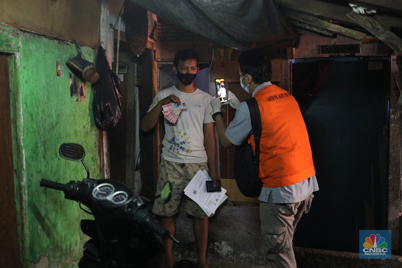 Penyaluran bansos Petugas PT Pos Indonesia melakukan penyaluran Bantuan Sosial Tunai secara door to door di Kawasan Petojo Selatan, Jakarta, Rabu (21/7/2021). Tahun ini bansos (BST) ditargetkan untuk menjangkau hingga 10 juta keluarga penerima, penyaluran pun dilakukan secara bertahap.
(CNBC Indonesia/ Tri Susilo)