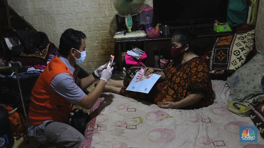 Petugas PT Pos Indonesia melakukan penyaluran Bantuan Sosial Tunai secara door to door di Kawasan Petojo Selatan, Jakarta, Rabu (21/7/2021). Tahun ini bansos (BST) ditargetkan untuk menjangkau hingga 10 juta keluarga penerima, penyaluran pun dilakukan secara bertahap. 
 (CNBC Indonesia/ Tri Susilo)