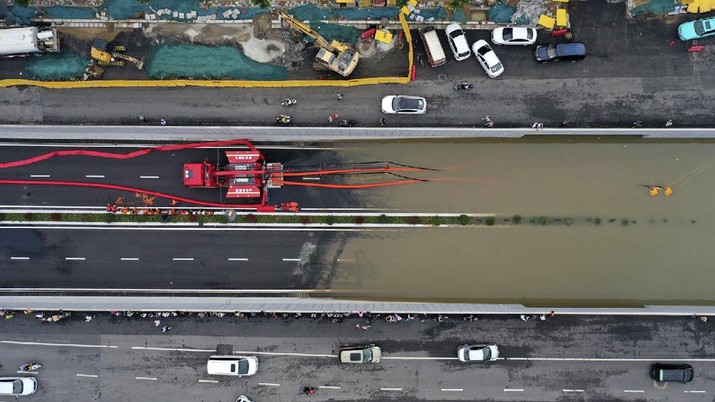 In this aerial photo released by Xinhua News Agency, firefighters pump rainwater from a road underpass in Zhengzhou in central China's Henan province on Wednesday, July 21, 2021. China's military has blasted a dam to release floodwaters threatening one of its most heavily populated provinces, as the death toll in widespread flooding rose to more than two dozens. (Ma Xiaoran/Xinhua via AP)