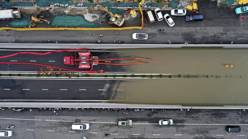 In this photo released by Xinhua News Agency, residents move their belongings across a flooded street in Zhengzhou in central China's Henan province on Wednesday, July 21, 2021. China's military has blasted a dam to release floodwaters threatening one of its most heavily populated provinces, as the death toll in widespread flooding rose to more than two dozens. (Zhu Xiang/Xinhua via AP)