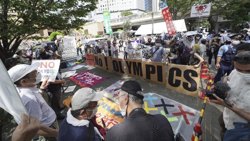 Anti-Olympics protesters march with banners in Tokyo on the opening day of the Tokyo 2020 Olympics Friday, July 23, 2021. A sign, center, reads 