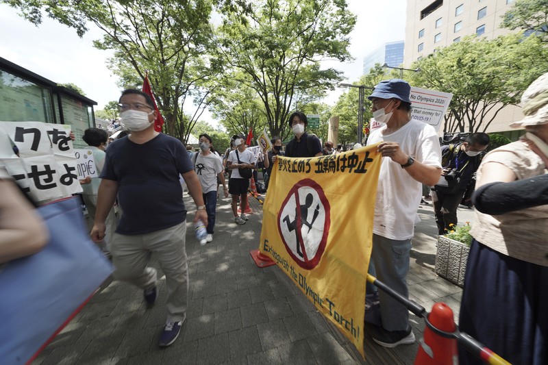 Demo Anti Olimpiade Anti-Olympics protesters march with banners in Tokyo on the opening day of the Tokyo 2020 Olympics Friday, July 23, 2021. A sign, center, reads