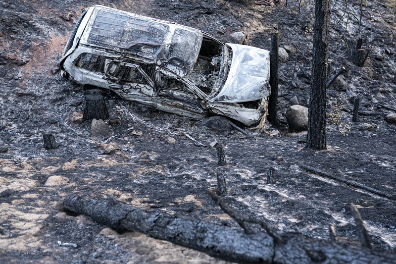 A sign damaged by the Bootleg Fire stands among the haze on Thursday, July 22, 2021, near Paisley, Ore. (AP Photo/Nathan Howard)