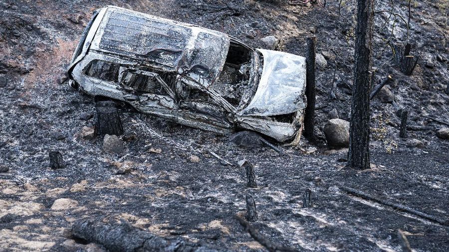 A sign damaged by the Bootleg Fire stands among the haze on Thursday, July 22, 2021, near Paisley, Ore. (AP Photo/Nathan Howard)