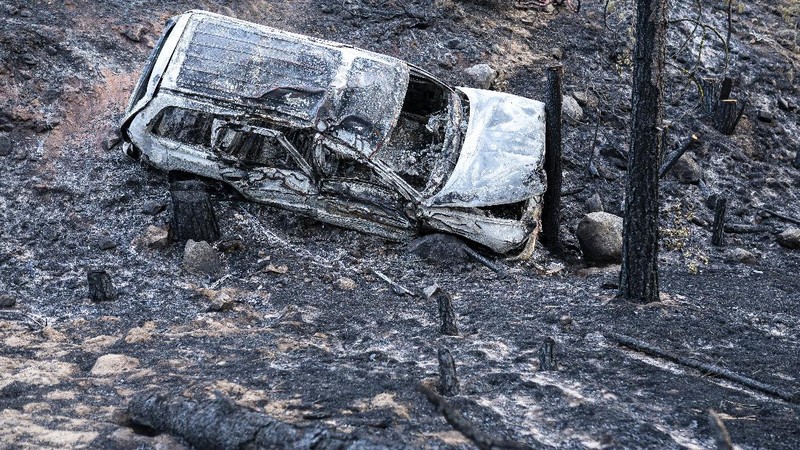 A sign damaged by the Bootleg Fire stands among the haze on Thursday, July 22, 2021, near Paisley, Ore. (AP Photo/Nathan Howard)