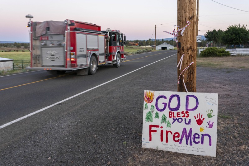 A sign damaged by the Bootleg Fire stands among the haze on Thursday, July 22, 2021, near Paisley, Ore. (AP Photo/Nathan Howard)