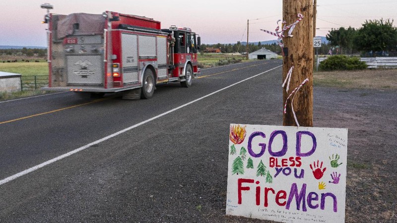 A sign damaged by the Bootleg Fire stands among the haze on Thursday, July 22, 2021, near Paisley, Ore. (AP Photo/Nathan Howard)