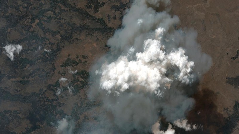 A sign damaged by the Bootleg Fire stands among the haze on Thursday, July 22, 2021, near Paisley, Ore. (AP Photo/Nathan Howard)
