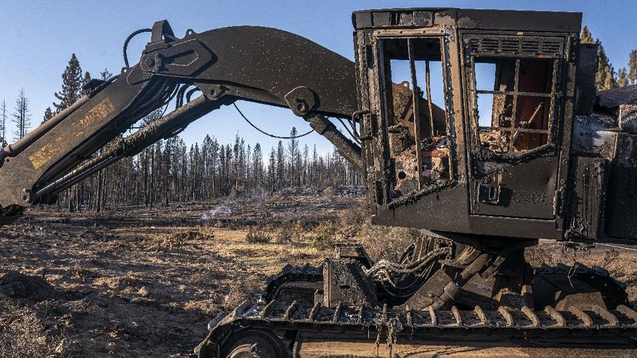 A sign damaged by the Bootleg Fire stands among the haze on Thursday, July 22, 2021, near Paisley, Ore. (AP Photo/Nathan Howard)
