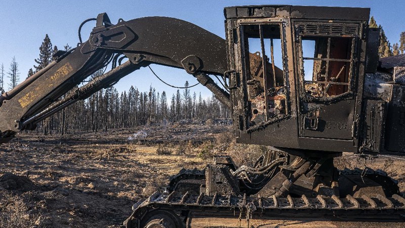 A sign damaged by the Bootleg Fire stands among the haze on Thursday, July 22, 2021, near Paisley, Ore. (AP Photo/Nathan Howard)