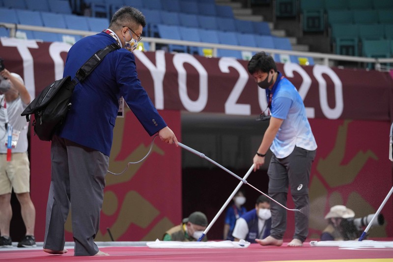 Penyemprotan disinfektan saat Olimpiade Tokyo 2020. (AP/Vincent Thian) Penyemprotan disinfektan saat Olimpiade Tokyo 2020. (AP/Vincent Thian)