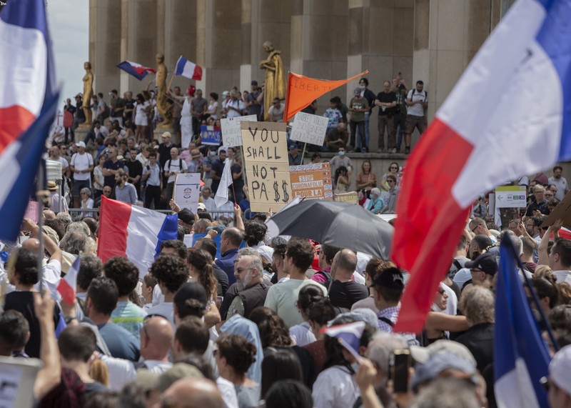 Thousands of protesters gather at Place Trocadero near the Eiffel Tower attend a demonstration in Paris, France, Saturday July 24, 2021, against the COVID-19 pass which grants vaccinated individuals greater ease of access to venues. (AP Photo/Rafael Yaghobzadeh)
