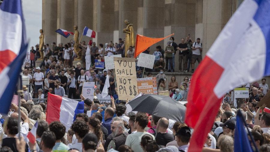 Thousands of protesters gather at Place Trocadero near the Eiffel Tower attend a demonstration in Paris, France, Saturday July 24, 2021, against the COVID-19 pass which grants vaccinated individuals greater ease of access to venues. (AP Photo/Rafael Yaghobzadeh)