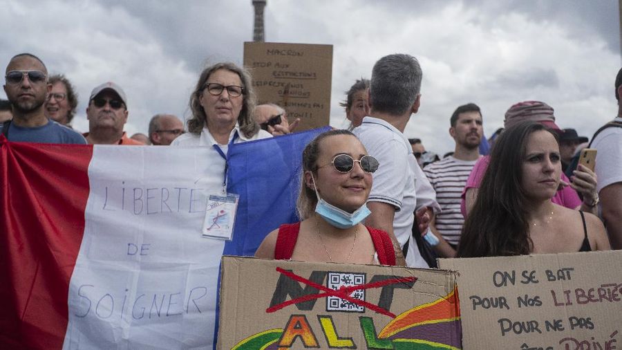 Thousands of protesters gather at Place Trocadero near the Eiffel Tower attend a demonstration in Paris, France, Saturday July 24, 2021, against the COVID-19 pass which grants vaccinated individuals greater ease of access to venues. (AP Photo/Rafael Yaghobzadeh)