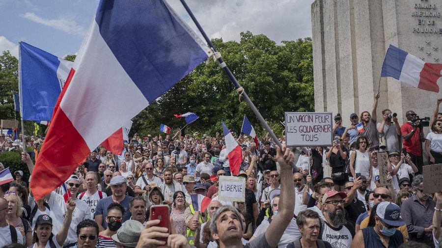 Thousands of protesters gather at Place Trocadero near the Eiffel Tower attend a demonstration in Paris, France, Saturday July 24, 2021, against the COVID-19 pass which grants vaccinated individuals greater ease of access to venues. (AP Photo/Rafael Yaghobzadeh)