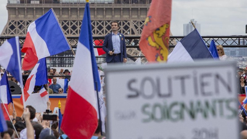 Thousands of protesters gather at Place Trocadero near the Eiffel Tower attend a demonstration in Paris, France, Saturday July 24, 2021, against the COVID-19 pass which grants vaccinated individuals greater ease of access to venues. (AP Photo/Rafael Yaghobzadeh)