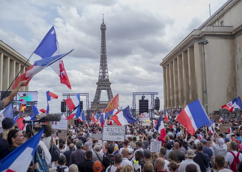 Demo di Prancis Thousands of protesters gather at Place Trocadero near the Eiffel Tower attend a demonstration in Paris, France, Saturday July 24, 2021, against the COVID-19 pass which grants vaccinated individuals greater ease of access to venues. (AP Photo/Rafael Yaghobzadeh)