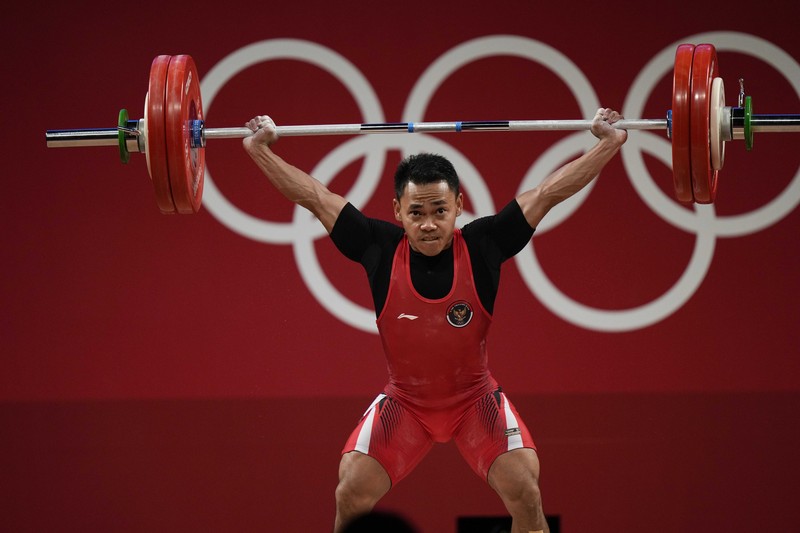 Eco Yuli Irawan of Indonesia competes in the men's 61kg weightlifting event, at the 2020 Summer Olympics, Sunday, July 25, 2021, in Tokyo, Japan. (AP Photo/Luca Bruno)