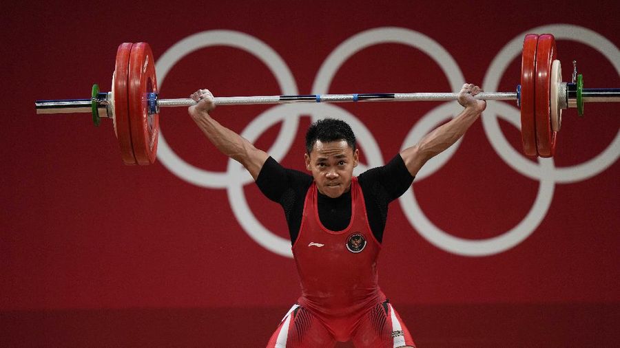 Eco Yuli Irawan of Indonesia competes in the men's 61kg weightlifting event, at the 2020 Summer Olympics, Sunday, July 25, 2021, in Tokyo, Japan. (AP Photo/Luca Bruno)