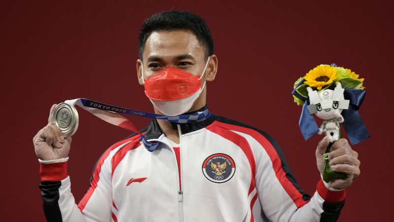 Eco Yuli Irawan of Indonesia competes in the men's 61kg weightlifting event, at the 2020 Summer Olympics, Sunday, July 25, 2021, in Tokyo, Japan. (AP Photo/Luca Bruno)