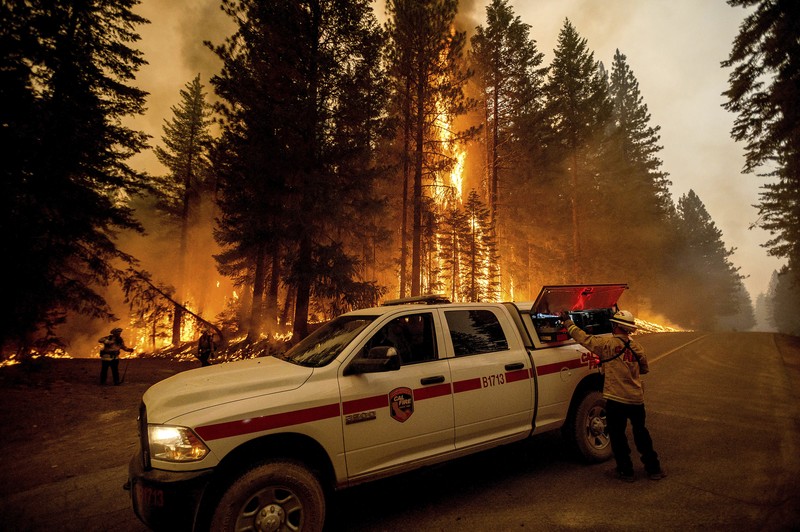 Kebakaran hutan di Plumas County, California Flames consume vehicles as the Dixie Fire tears through the Indian Falls community in Plumas County, Calif., Saturday, July 24, 2021. The fire destroyed multiple residences in the area. (AP Photo/Noah Berger)