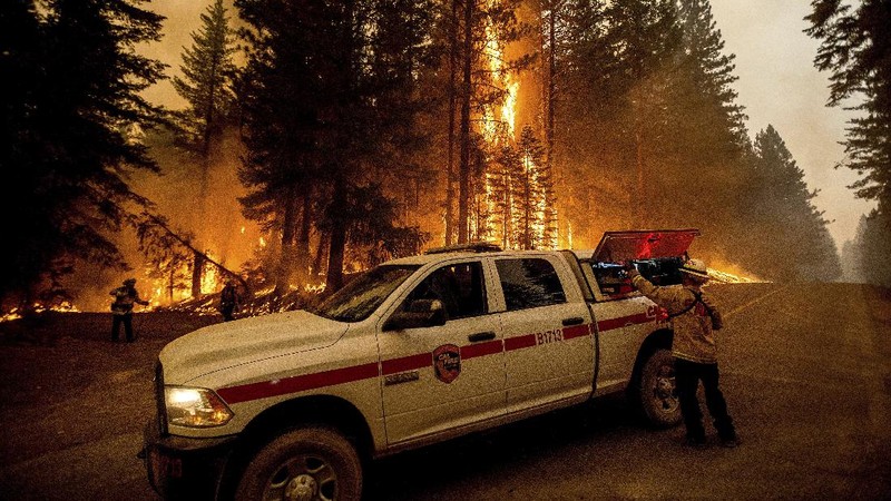 Flames consume vehicles as the Dixie Fire tears through the Indian Falls community in Plumas County, Calif., Saturday, July 24, 2021. The fire destroyed multiple residences in the area. (AP Photo/Noah Berger)