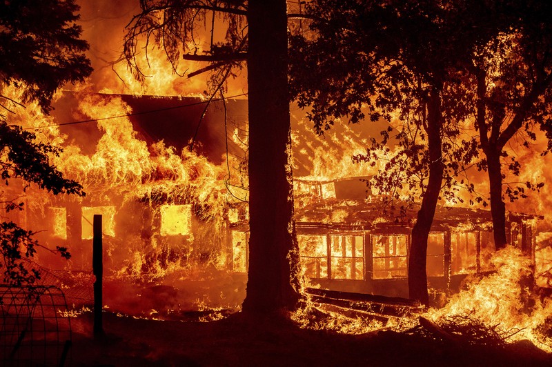 Flames consume vehicles as the Dixie Fire tears through the Indian Falls community in Plumas County, Calif., Saturday, July 24, 2021. The fire destroyed multiple residences in the area. (AP Photo/Noah Berger)