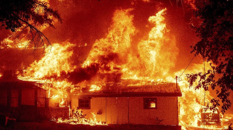 Flames consume vehicles as the Dixie Fire tears through the Indian Falls community in Plumas County, Calif., Saturday, July 24, 2021. The fire destroyed multiple residences in the area. (AP Photo/Noah Berger)