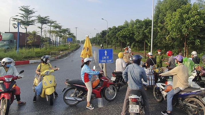 People are turned away at a checkpoint at an entrance to Hanoi, Vietnam, Saturday, July 24, 2021. Vietnam announced a 15-day lockdown in the capital Hanoi starting Saturday as a coronavirus surge spread from the southern Mekong Delta region. (AP Photo/Hieu Dinh)