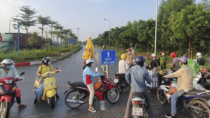 People are turned away at a checkpoint at an entrance to Hanoi, Vietnam, Saturday, July 24, 2021. Vietnam announced a 15-day lockdown in the capital Hanoi starting Saturday as a coronavirus surge spread from the southern Mekong Delta region. (AP Photo/Hieu Dinh)
