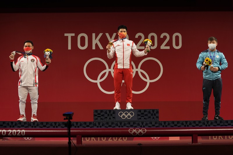 Eco Yuli Irawan of Indonesia competes in the men's 61kg weightlifting event, at the 2020 Summer Olympics, Sunday, July 25, 2021, in Tokyo, Japan. (AP Photo/Luca Bruno)