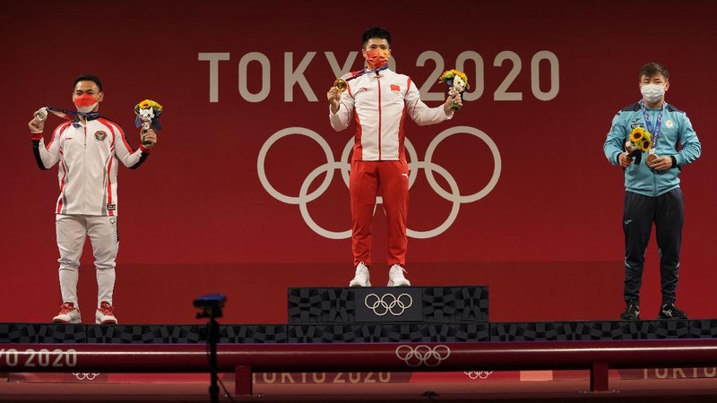 Eco Yuli Irawan of Indonesia competes in the men's 61kg weightlifting event, at the 2020 Summer Olympics, Sunday, July 25, 2021, in Tokyo, Japan. (AP Photo/Luca Bruno)