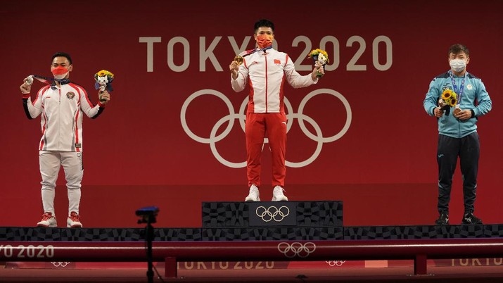 Peraih medali emas Li Fabin dari China (tengah) berdiri dengan peraih medali perak Eko Yuli Irawan dari Indonesia, (kiri) dan peraih medali perunggu Igor Son dari Kazakhstan, (kanan) setelah kompetisi angkat besi 61kg putra di Olimpiade 2020, di Tokyo, Jepang, Minggu, 25 Juli 2021. (AP/Luca Bruno) Gold medalist Li Fabin of China, center, stands with silver medalist Eco Yuli Irawan of Indonesia, left, and bronze medalist Igor Son of Kazakhstan, right, after the men's women's kg weightlifting competition in the men's 61kg weightlifting event, at the 2020 Summer Olympics, Sunday, July 25, 2021, in Tokyo, Japan. (AP Photo/Luca Bruno)