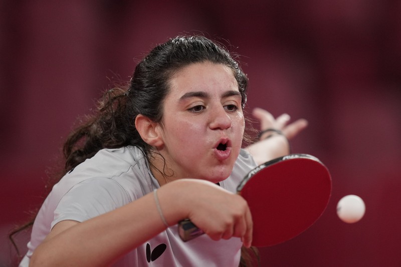 Syria's Hend Zaza competes during women's table tennis singles preliminary round match against Austria's Liu Jia at the 2020 Summer Olympics, Saturday, July 24, 2021, in Tokyo. (AP Photo/Kin Cheung)