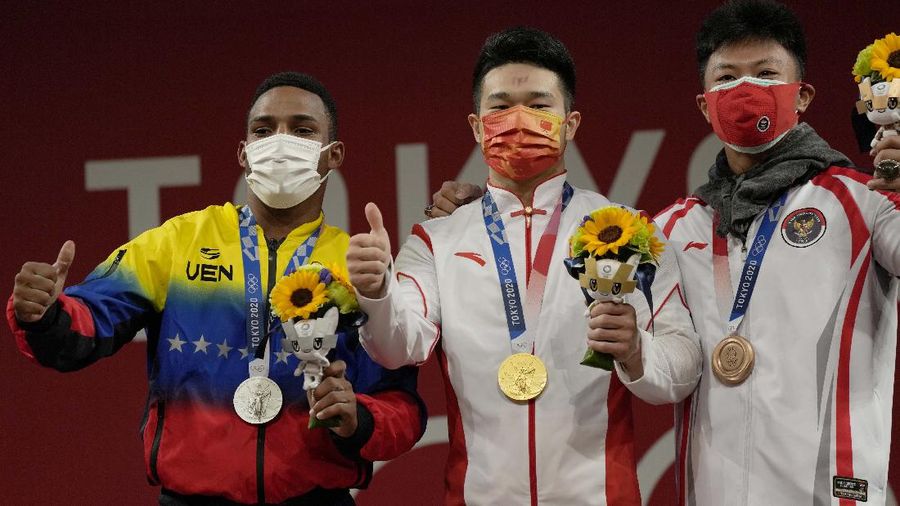 Rhamat Erwin Abdullah of Indonesia competes in the men's 73kg weightlifting event, at the 2020 Summer Olympics, Wednesday, July 28, 2021, in Tokyo, Japan. (AP Photo/Luca Bruno)