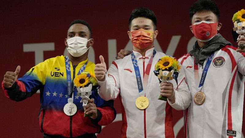 Rhamat Erwin Abdullah of Indonesia competes in the men's 73kg weightlifting event, at the 2020 Summer Olympics, Wednesday, July 28, 2021, in Tokyo, Japan. (AP Photo/Luca Bruno)