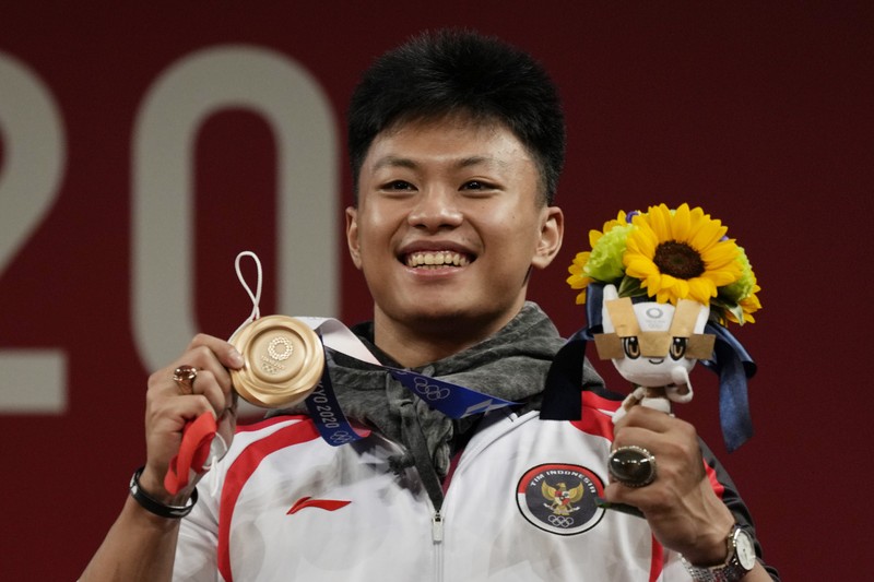Rhamat Erwin Abdullah of Indonesia competes in the men's 73kg weightlifting event, at the 2020 Summer Olympics, Wednesday, July 28, 2021, in Tokyo, Japan. (AP Photo/Luca Bruno)