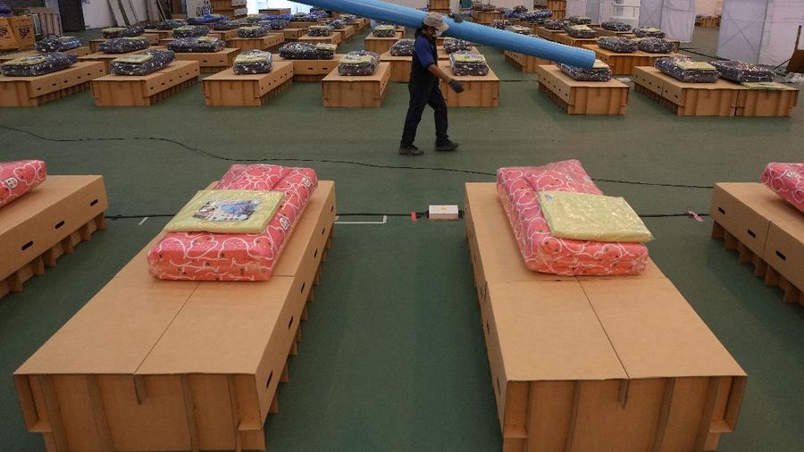 Para relawan di Thailand mengubah sebuah gudang kargo di Bandara Don Mueang, Bangkok, menjadi sebuah rumah sakit (RS) darurat. (AP/Sakchai Lalit)