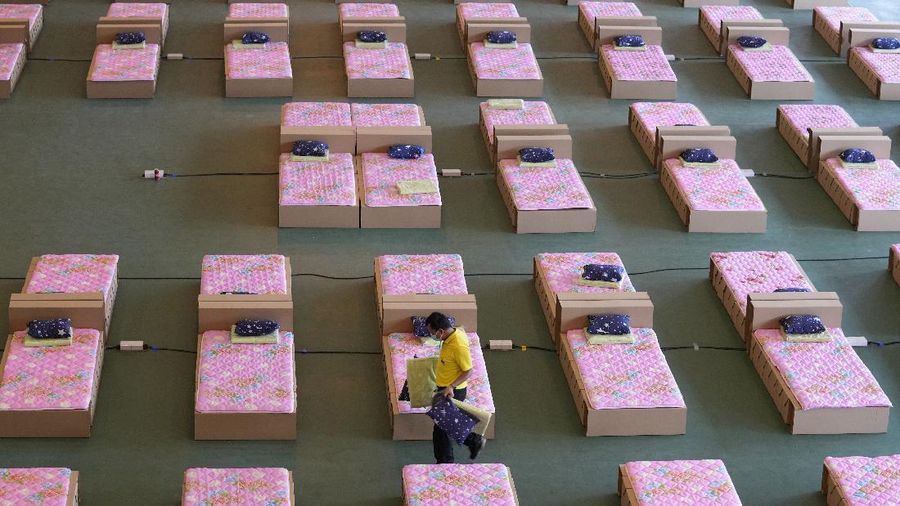 Para relawan di Thailand mengubah sebuah gudang kargo di Bandara Don Mueang, Bangkok, menjadi sebuah rumah sakit (RS) darurat. (AP/Sakchai Lalit)