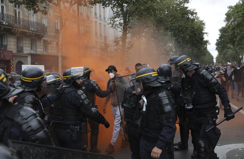 Protestors march waving French flags during a demonstration in Paris, France, Saturday, July 31, 2021. Demonstrators gathered in several cities in France on Saturday to protest against the COVID-19 pass, which grants vaccinated individuals greater ease of access to venues. (AP Photo/Adrienne Surprenant)